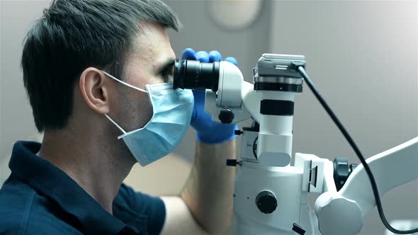 Dentist Is Looking Through Dental Microscope