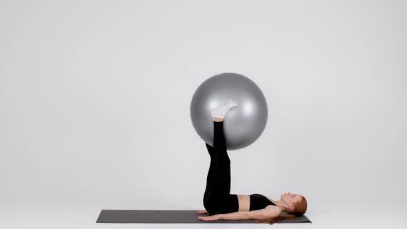 Athletic Young Female Training With Fitball Over White Background In Studio alt