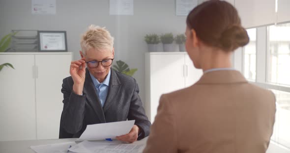 Mature Female Manager Smiling and Handshaking with European Businesswoman After Interview in Office alt