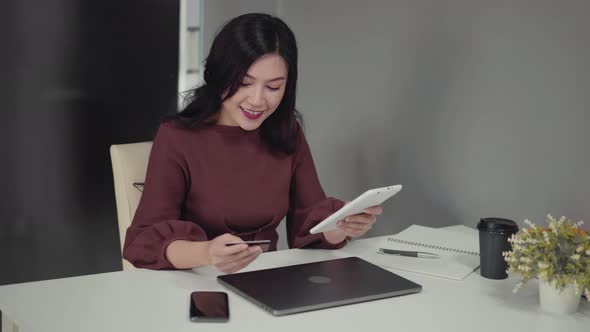 happy woman using digital tablet for online shopping with credit card