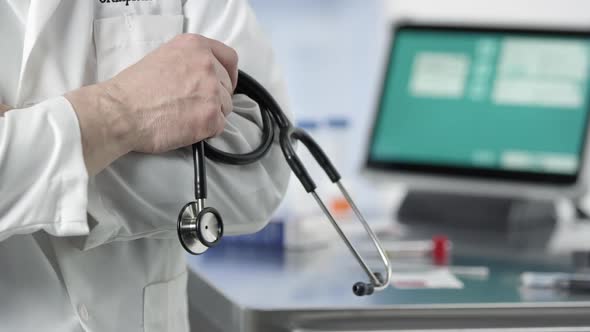 Doctor holding stethoscope crossing his arms in lab alt