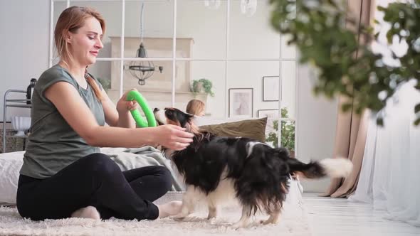 Woman European Appearance Plays with Her Beautiful Fluffy Dog Cozy Modern Bedroom Front Bed alt