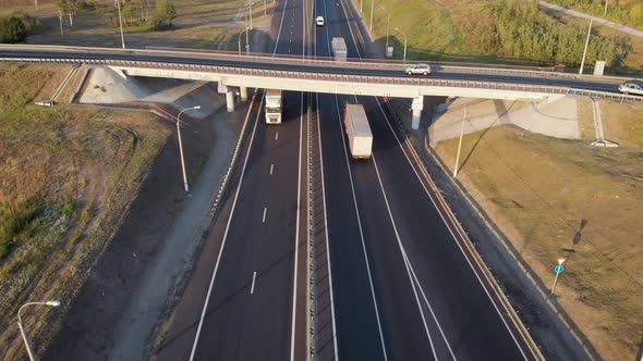 Aerial View. Interchange on the Intercity Highway. Cars and Trucks Travel in Different Directions alt