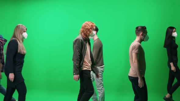 Crowd of People People in Medical Masks Walking Along the Road on a Green Background a Lot of alt