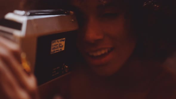 Woman With Afro Hair Looking Through Vintage 8Mm Camera alt
