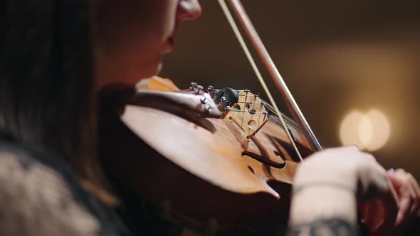 Closeup of Old Violin in Hands of Woman Female Musician is Playing Violin and Rehearsing Sonata in alt