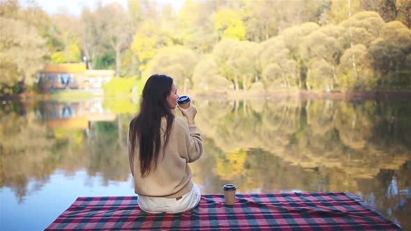 Fall Concept - Beautiful Woman Drinking Coffee in Autumn Park