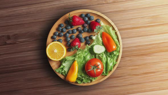 Variety of Color Fruits and Berries and Vegetables with Greens are Rotating on the Plate alt
