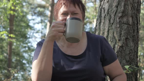 A Middle Aged Lady Happily Drinking Her Morning Coffee