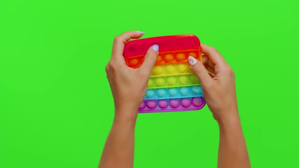 Closeup of Girl Hands Playing Squeezing Antistress Toys Simple Dimple Game Isolated on Chroma Key alt