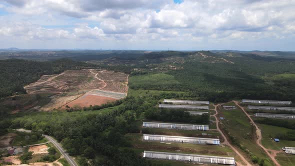 Aerial view of clear sky, hills and chicken farm house in Malaysia