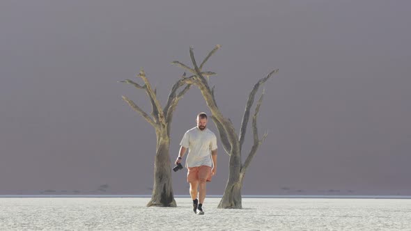 Lone Traveler With Camera On Hand Walking In The Salt Pan At Sossusvlei In Namib-Naukluft National P alt