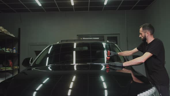 Professional Car Ceramics Worker Applies a Layer of Ceramics Protective Rain alt