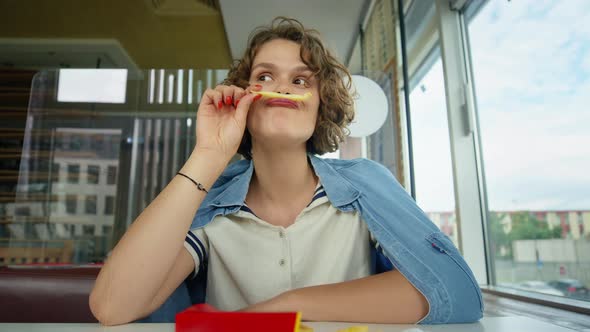 Young Happy Playful Woman Grimace Play with Fries alt