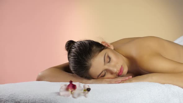 Woman Is Relaxing and Waiting for Massage. Pink Studio Background alt