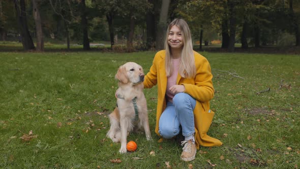 Woman Sitting at Park Near Her Adorable French Retriever alt