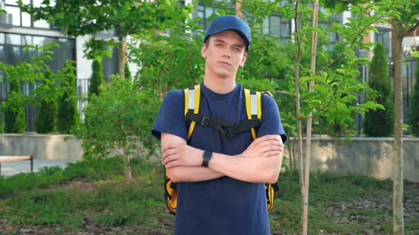 Zoom in Food Delivery Young Man Courier with Thermal Backpack Crosses Hands alt