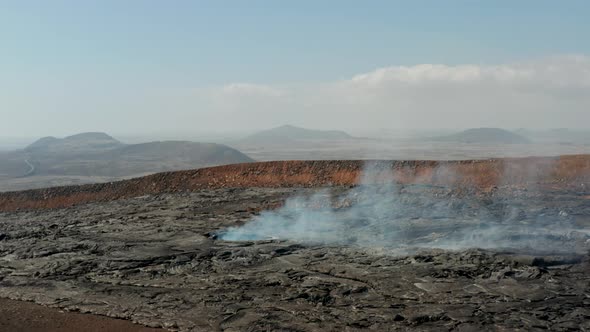 Fly Over Large Hole in Cooling Lava Layer Emitting Smoke alt