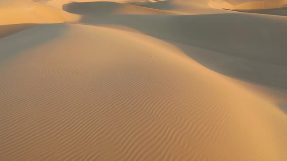  Aerial Drone Flying Over Magical Waves of Sand Dunes in Golden Sunset Light alt