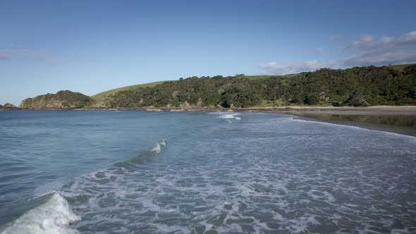 Waves Crashing Towards White Sandy Beach Of Tawharanui Regional Park - Aerial shot alt