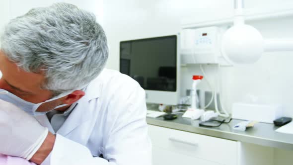 Dentist examining a female patient with dental tools alt