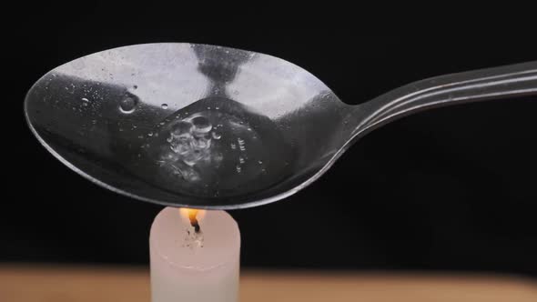 Cooking Drugs in a Spoon on a Candle Flame alt