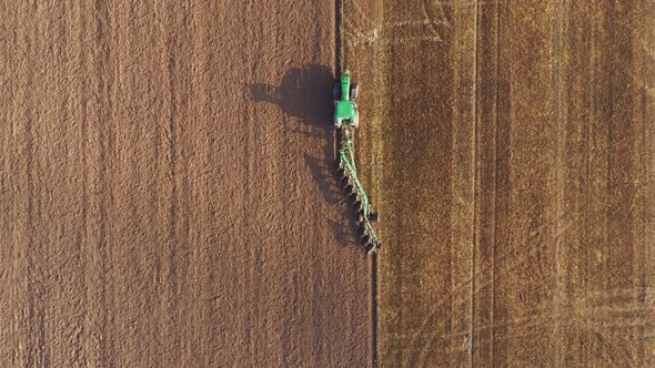 Agricultural Works In Field Tractor Plough The Land With A Plow After Harvesting alt