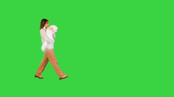 Smiling Woman Posing on Camera with Bichon Frise on a Green Screen Chroma Key