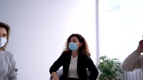 A Female Psychologist in a Mask Leads a Psychological Therapy Meeting During a Pandemic alt