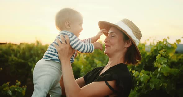 Young Mom Have Fun Time with Her Cute Little Child in French Provence Vineyard During Summer alt