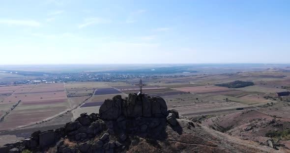 View Of A Cross At Pricopan Peak With Farmland Backdrop In Macin Mountain, Dobrogea alt
