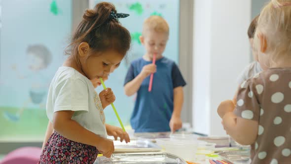 Multiethnic Group of Toddlers Milk Painting with the Teacher Helping Them Using Nontoxic Paint Food alt