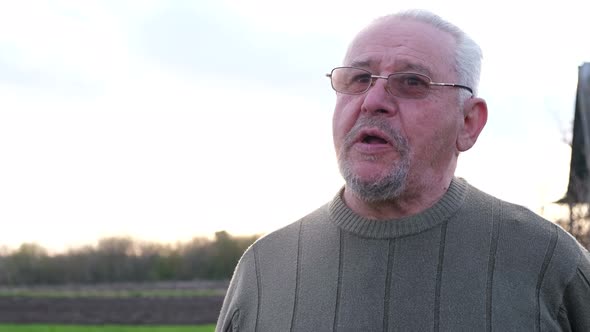 Happy Grandfather Actively Talks Against the Background of Sunlight alt