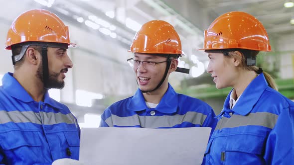 Asian engineer taking in international colleagues at factory