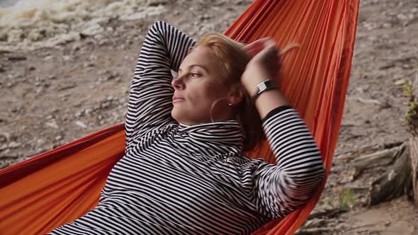 Mature Blond Woman Lying in Hammock at Beach alt