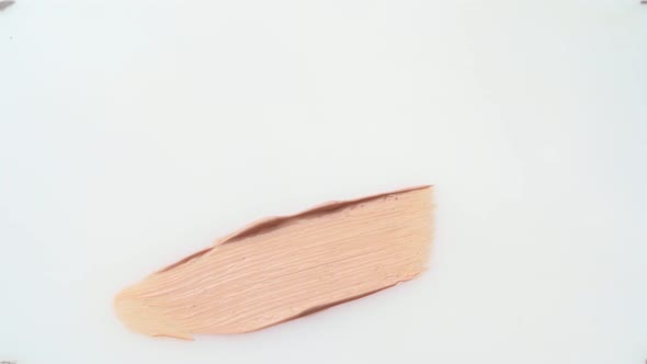 Facial Foundation Smudge Made with a Brush on White Makeup Palette Close Up alt