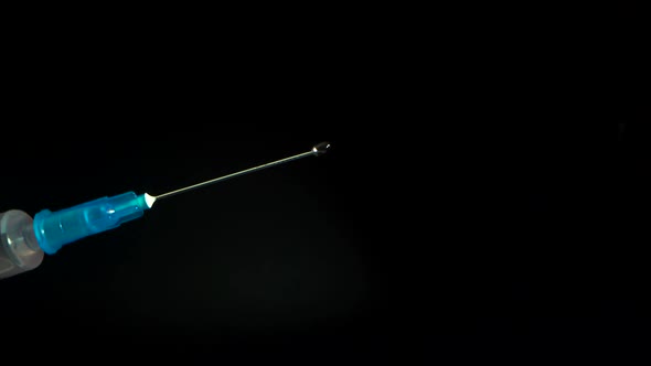 Second Wave of Pandemic. Syringe with a Needle. The Doctor Releases Air From the Syringe. Drops of