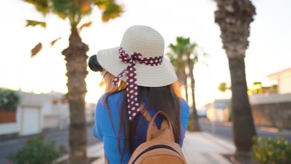 Photographer Tourist Woman Taking Photos with Camera in a Beautiful Tropical Landscape at Sunset alt
