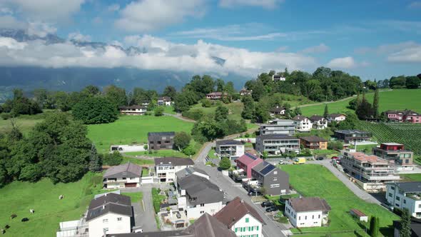 Aerial View of Liechtenstein with Houses on Green Fields in Alps Mountain Valley alt
