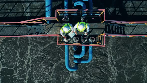 Top View of Two Workers at the Wastewater Treatment Site alt
