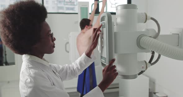 In the Hospital Man Standing Face Against the Wall While Medical Technician alt