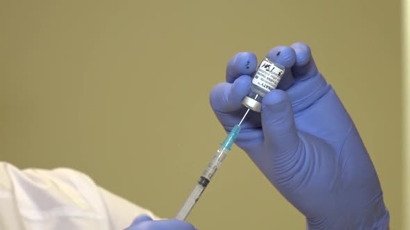 A Medic Draws a Vaccine From a Vial Into a Syringe
