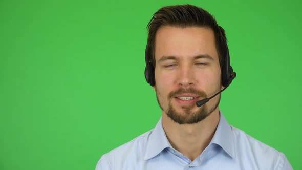 A Young Handsome Call Center Agent Talks To the Camera with a Smile - Closeup - Green Screen Studio alt