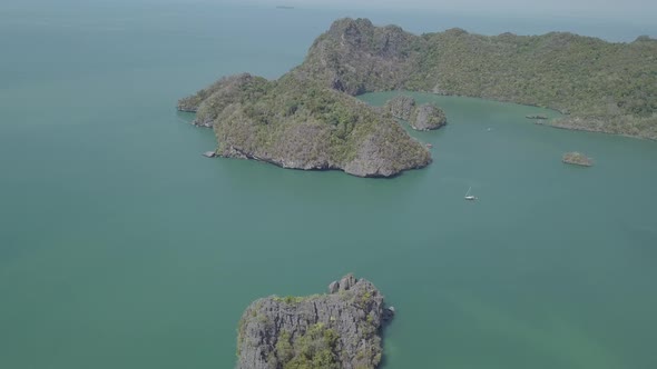 Aerial footage of island in sea. Boat float near. Park Kilim Geforest, Langkawi, Malaysia. Nature