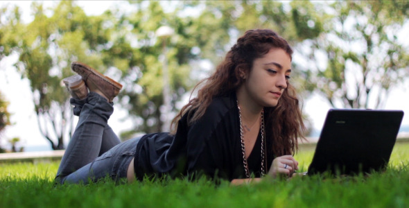 Girl Using Notebook on The Grass