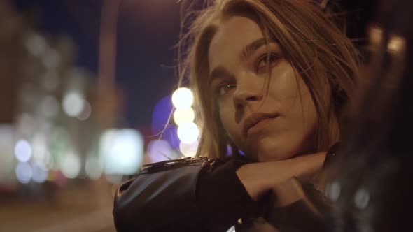 Young Girl in Car Leans Out Passenger Side Car Window Wind Stirs Her Hair She Looks at the Night alt