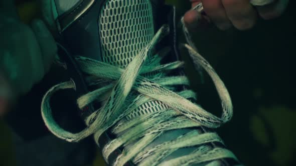 Ice Hockey Player Tightening Laces on His Skates Preparing for the Game