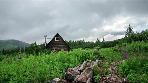 Grey Clouds Moving over Small Mountains Hut in Green Wilderness Nature alt