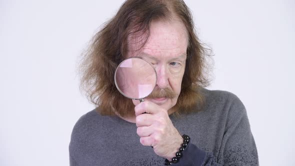 Senior Man with Mustache Using Magnifying Glass alt