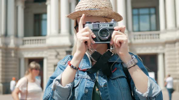 Young woman tourist taking a picture of a city on vacation